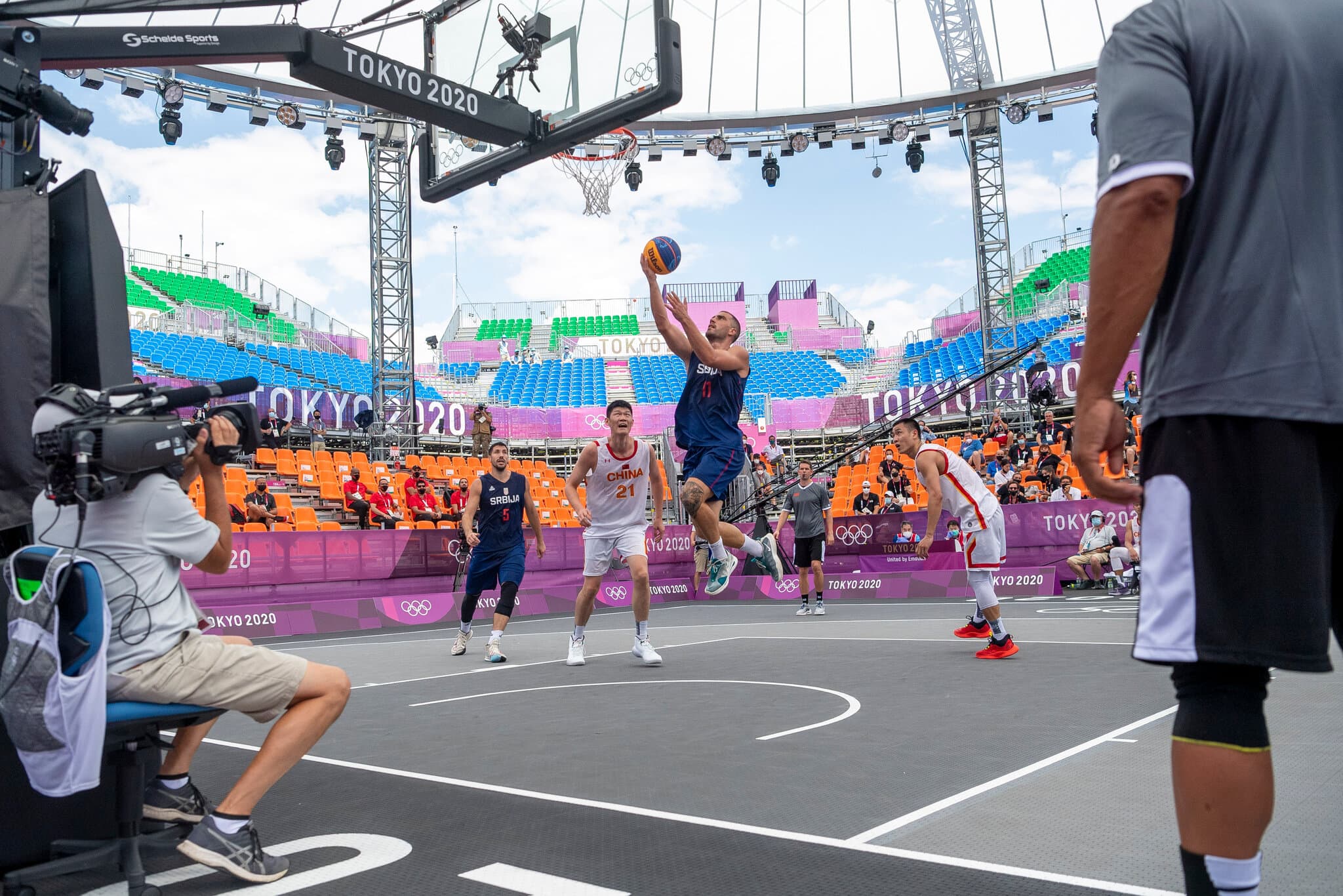 A player driving to the basket during a competitive 3x3 basketball game
